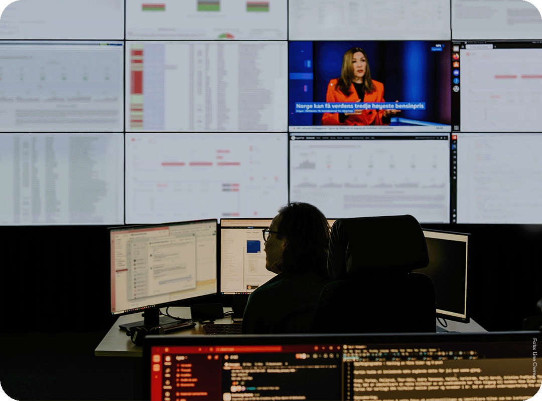 Mann i operasjonssentral ser på PC-skjermer
