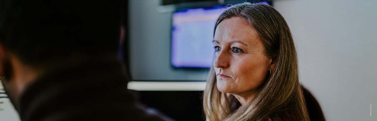 Alvorlig kvinne ser på en PC-skjerm