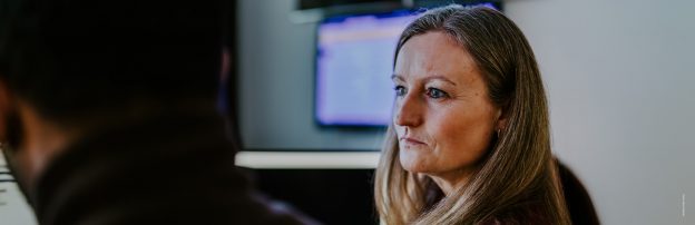 Alvorlig kvinne ser på en PC-skjerm